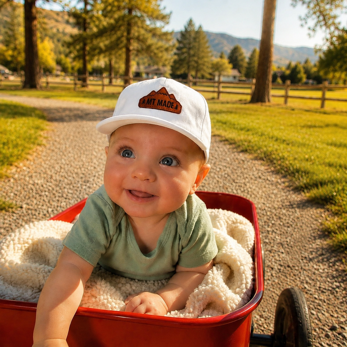 Baby wearing Montana Made white hat outdoors